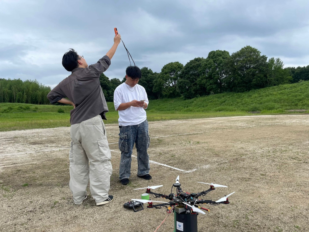 本学の斎藤教授が作製したドローンによるCanSat投下準備